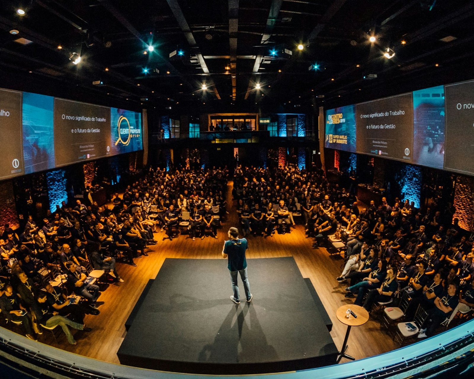Público em evento presencial durante apresentação em auditório