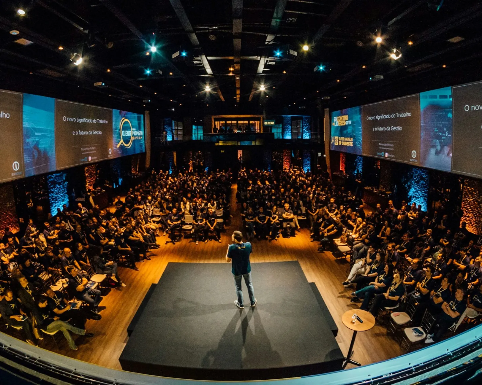Público em evento presencial durante apresentação em auditório
